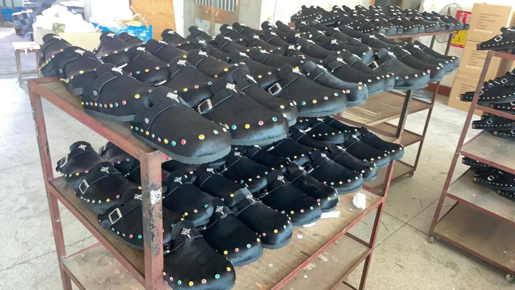 Black Clog Slippers: Stylish black clogs with colorful adornments ready for shipment, made at JNP Footwear Factory