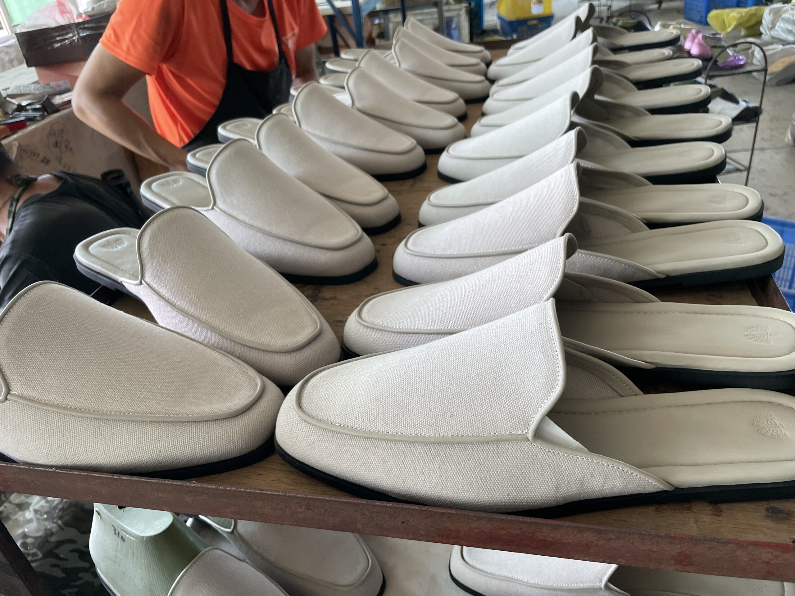 Custom white slipper uppers with grey trim details on the JNP Footwear production line